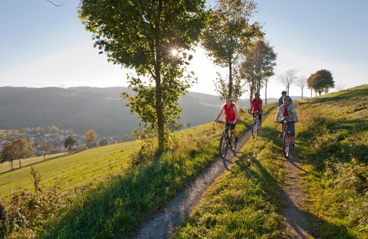 Cyclists on a farm track through rolling autumn countryside in the Sauerland