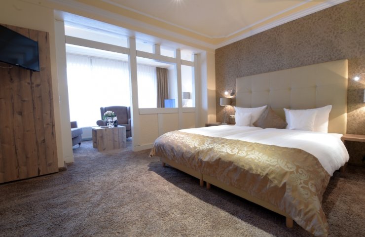 Comfort double room with large double bed and bright seating area by the window