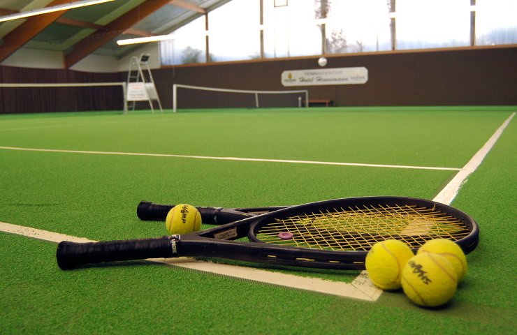 Tennis rackets and balls on the carpet court of the Hotel Hennemann indoor tennis hall