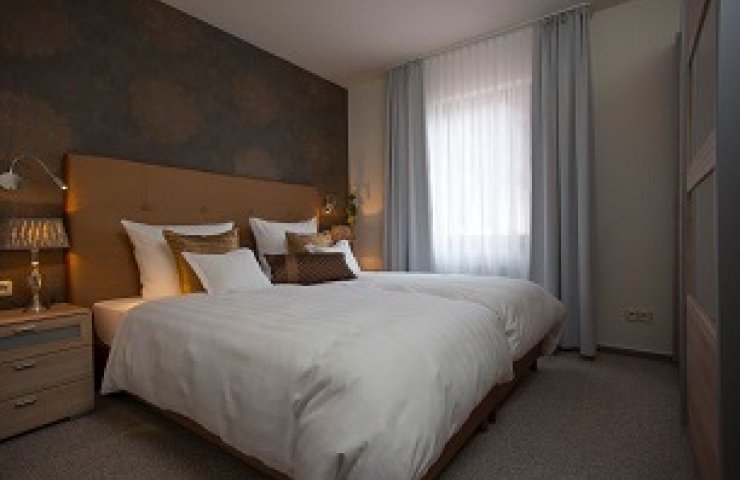 Bedroom of the exclusive apartment with double bed and bedside lamps