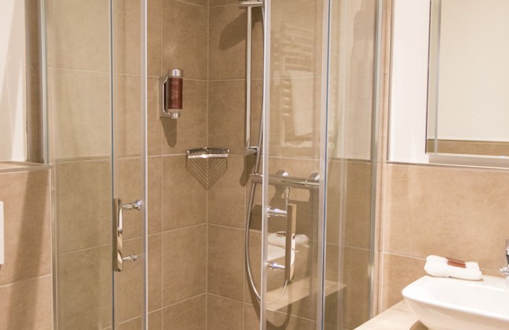 New bathroom in a small double room with glass shower and countertop basin