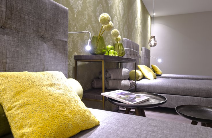 Relaxation room in the wellness area with upholstered loungers, yellow cushions and reading lamps