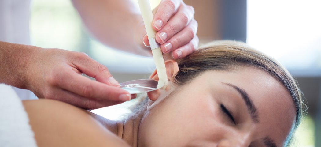 Woman relaxing during an ear candle treatment